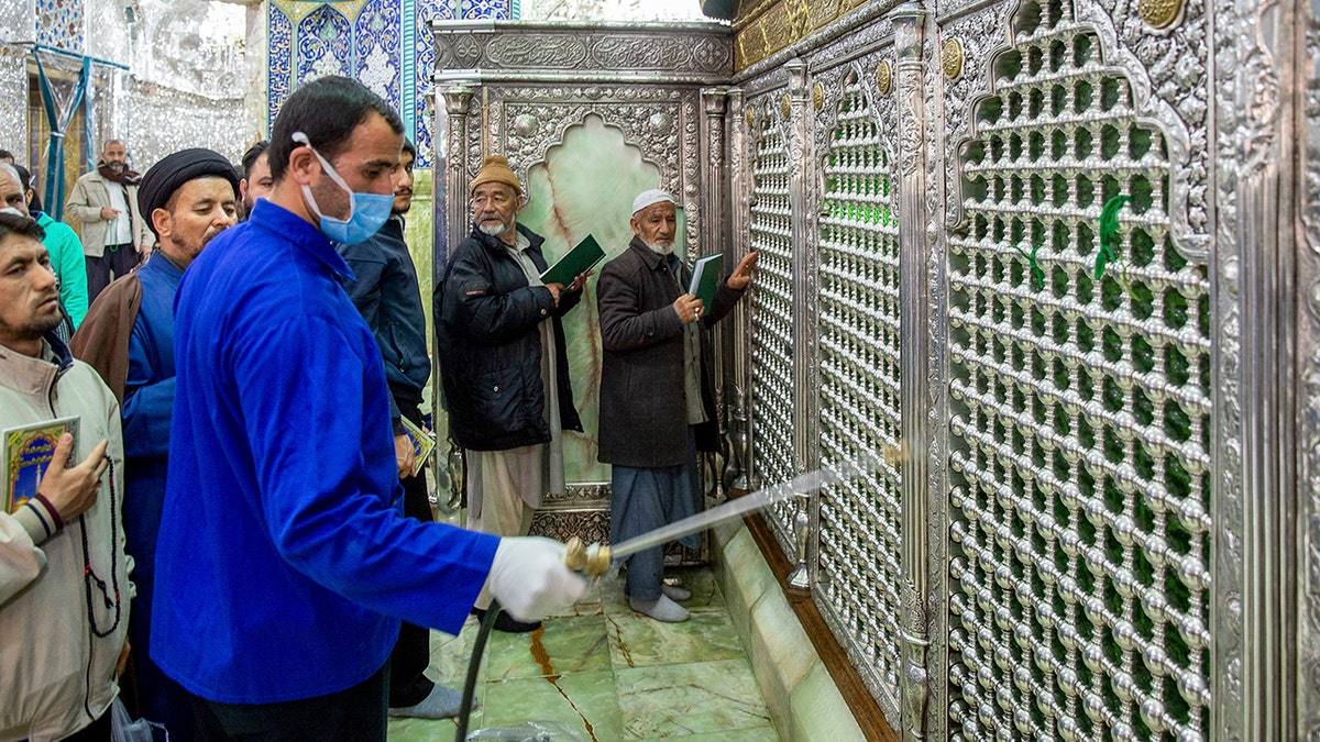 In this Monday, Feb. 24, 2020, photo, a man disinfects the shrine of Saint Masoumeh against coronavirus in the city of Qom 78 miles south of the capital Tehran, Iran. (Ahmad Zohrabi/ISNA via AP)