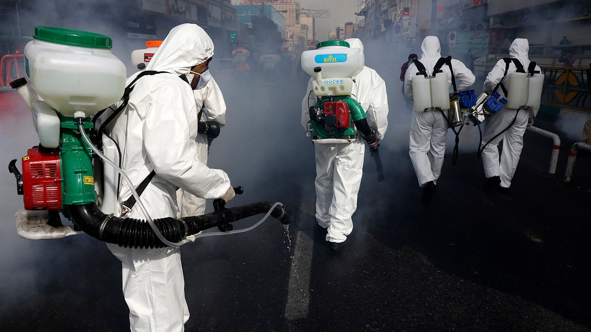 Firefighters disinfect a street against the new coronavirus in western Tehran on Friday as the virus continues to spread throughout the nation. (AP Photo/Vahid Salemi)
