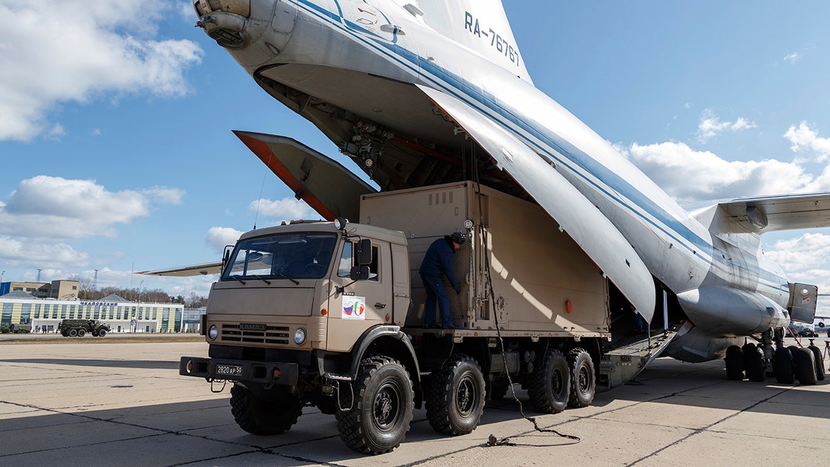 A military truck loads onto a Il-76 cargo plane in Chkalovsky military airport outside Moscow in preparation to deliver aid to Italy. (Alexei Yereshko, Russian Defense Ministry Press Service via AP)