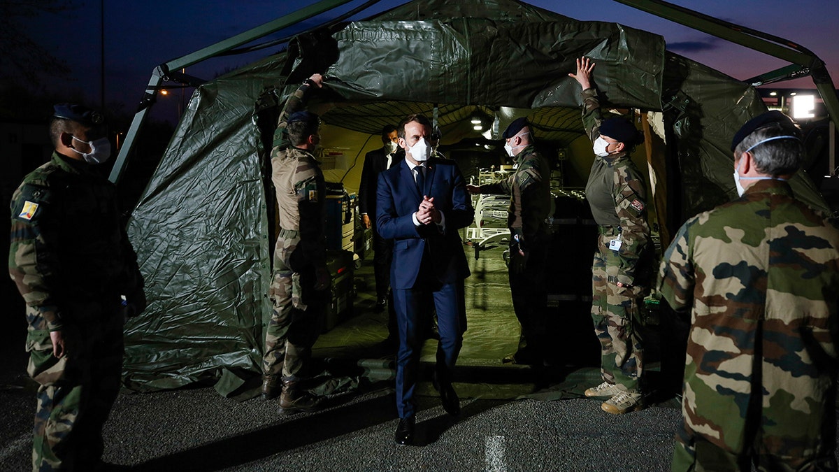 Macron wears a face mask during his visit at the military field hospital in Mulhouse on Wednesday. (Mathieu Cugnot/Pool via AP)