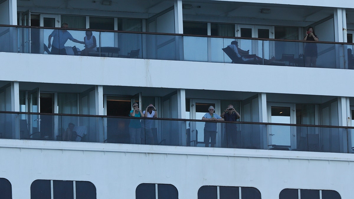 Passengers look out from the Zaandam cruise ship, anchored in the bay of Panama City. (AP Photo/Arnulfo Franco)