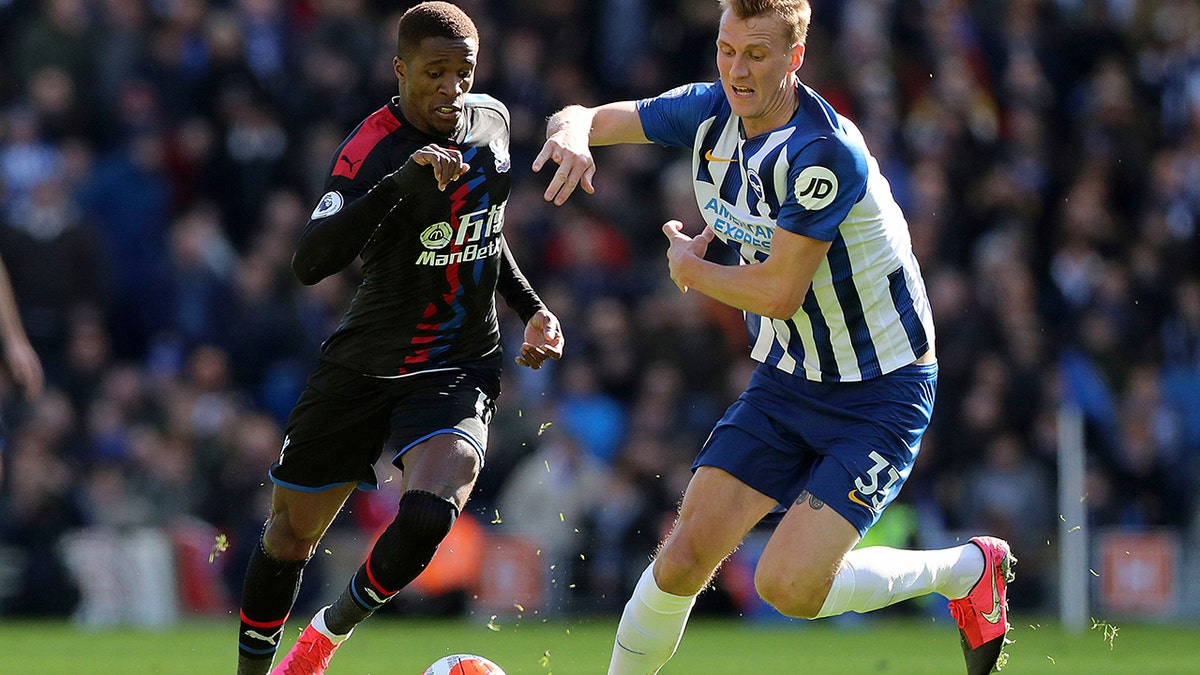 Brighton and Hove Albion's Dan Burn, right, and Crystal Palace's Wilfried Zaha in action during their English Premier League soccer match at the AMEX Stadium in Brighton, England, Saturday Feb. 29, 2020. (Gareth Fuller/PA via AP)