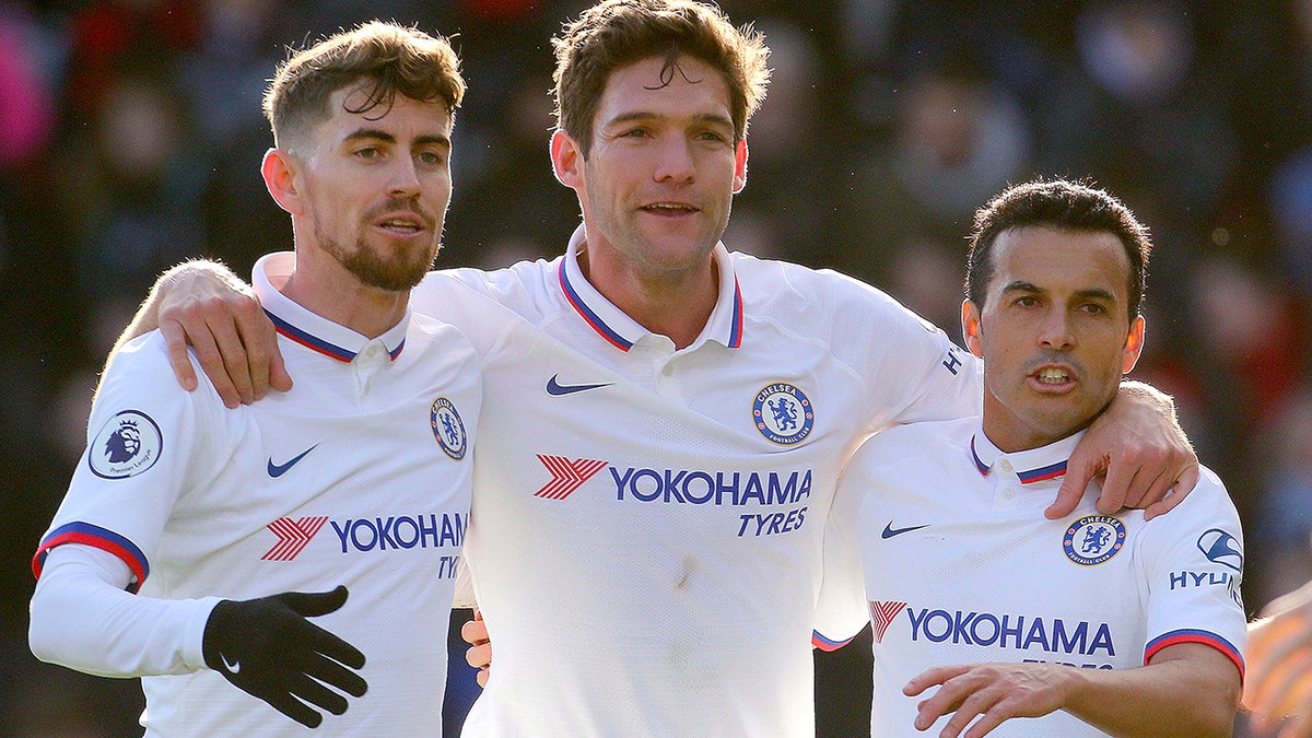 Chelsea's Marcos Alonso, centre, celebrates with team-mates Jorginho, left, and Pedro after scoring his side's first goal of the game against Bournemouth, in the English Premier League soccer match at the Vitality Stadium in Bournemouth, England, Saturday Feb. 29, 2020. (Mark Kerton/PA via AP)