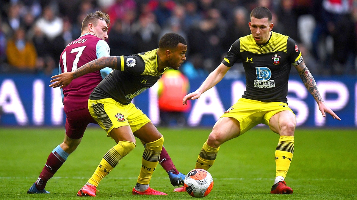 West Ham United's Jarrod Bowen, left, battles for the ball against Southampton's Ryan Bertrand, center, and Pierre-Emile Hojbjerg during their English Premier League soccer match at London Stadium, in London, Saturday, Feb. 29, 2020. (Victoria Jones/PA via AP)