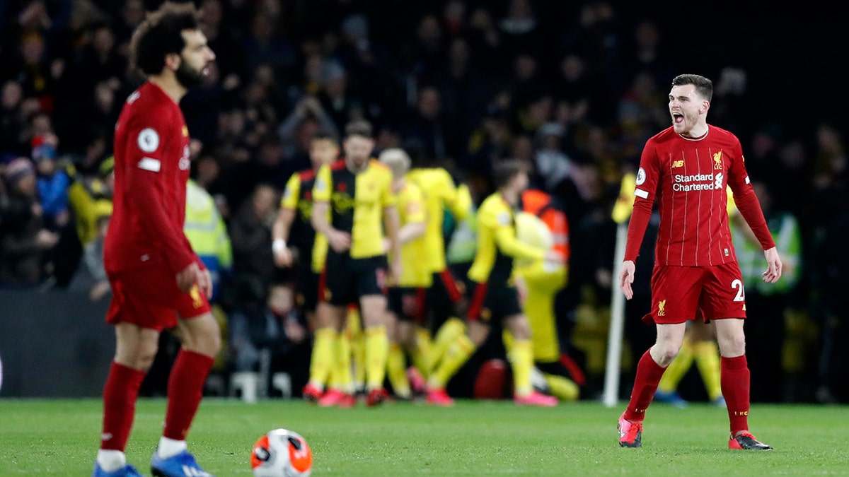 Liverpool's Andrew Robertson, right, and Liverpool's Mohamed Salah, left, react after Watford's Troy Deeney scores his side's third goal during the English Premier League soccer match between Watford and Liverpool at Vicarage Road stadium, in Watford, England, Saturday, Feb. 29, 2020. (AP Photo/Alastair Grant)