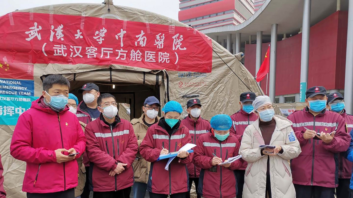 In this Feb. 14, 2020, photo released by Zhang Junjian, medical workers attend a morning conference outside a tent on the square in front of the Wuhan Living Room Temporary hospital in Wuhan in central China's Hubei province. Wuhan was the epicenter of the initial coronavirus outbreak in China. (Zhang Junjian via AP)