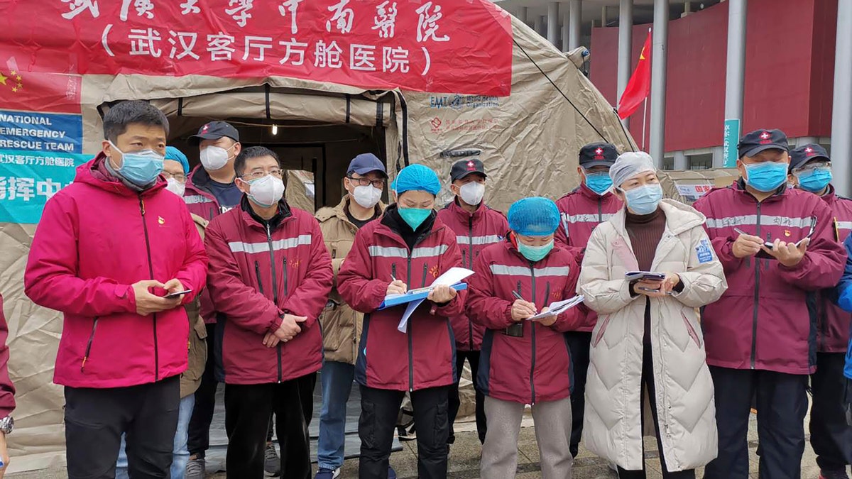 Medical workers attend a a morning conference outside a tent on the square in front of the Wuhan Living Room Temporary hospital in Wuhan in central China's Hubei province in this February photo.