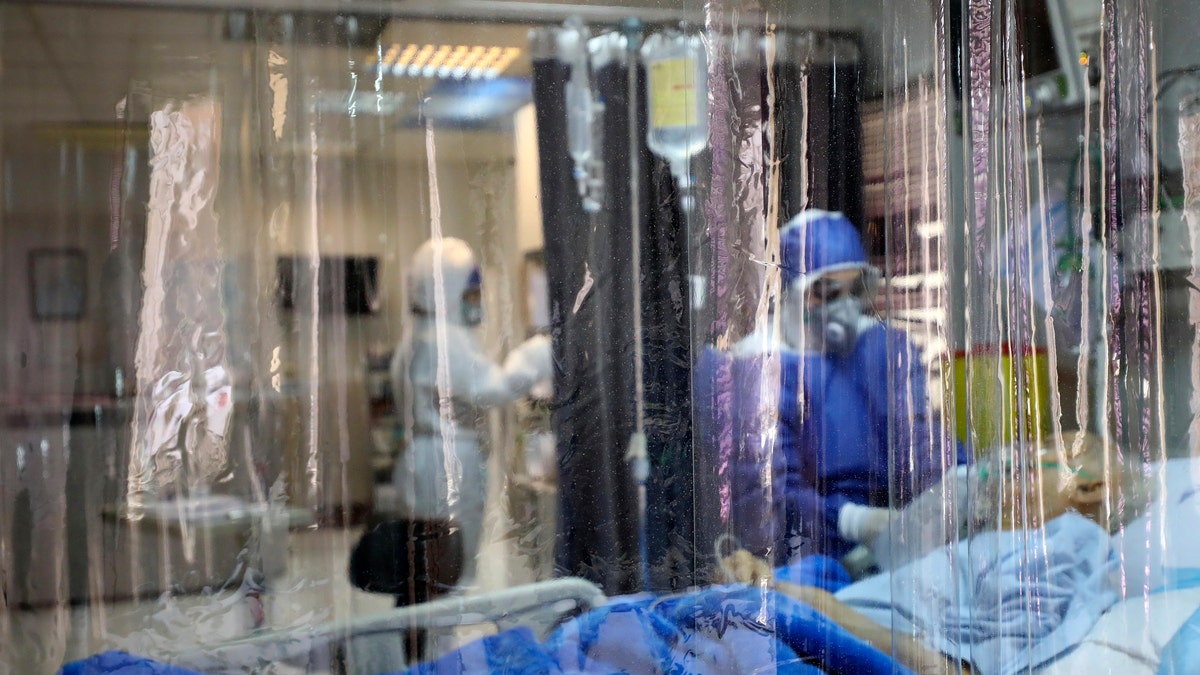 In this Sunday, March 1, 2020 photo, a medic treats a patient infected with coronavirus, at a hospital in Tehran, Iran.  (Koosha Mahshid Falahi/Mizan News Agency via AP)