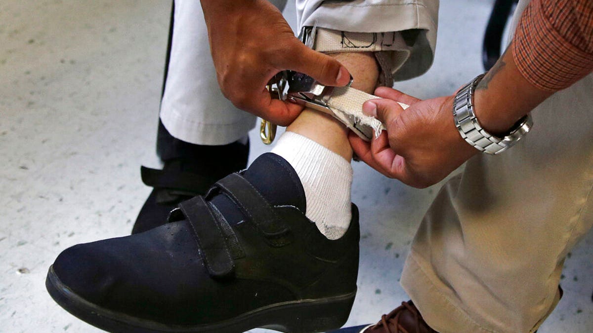 FILE: A therapist checks the ankle strap of an electrical shocking device on a student during an exercise program at the Judge Rotenberg Educational Center in Canton, Mass.