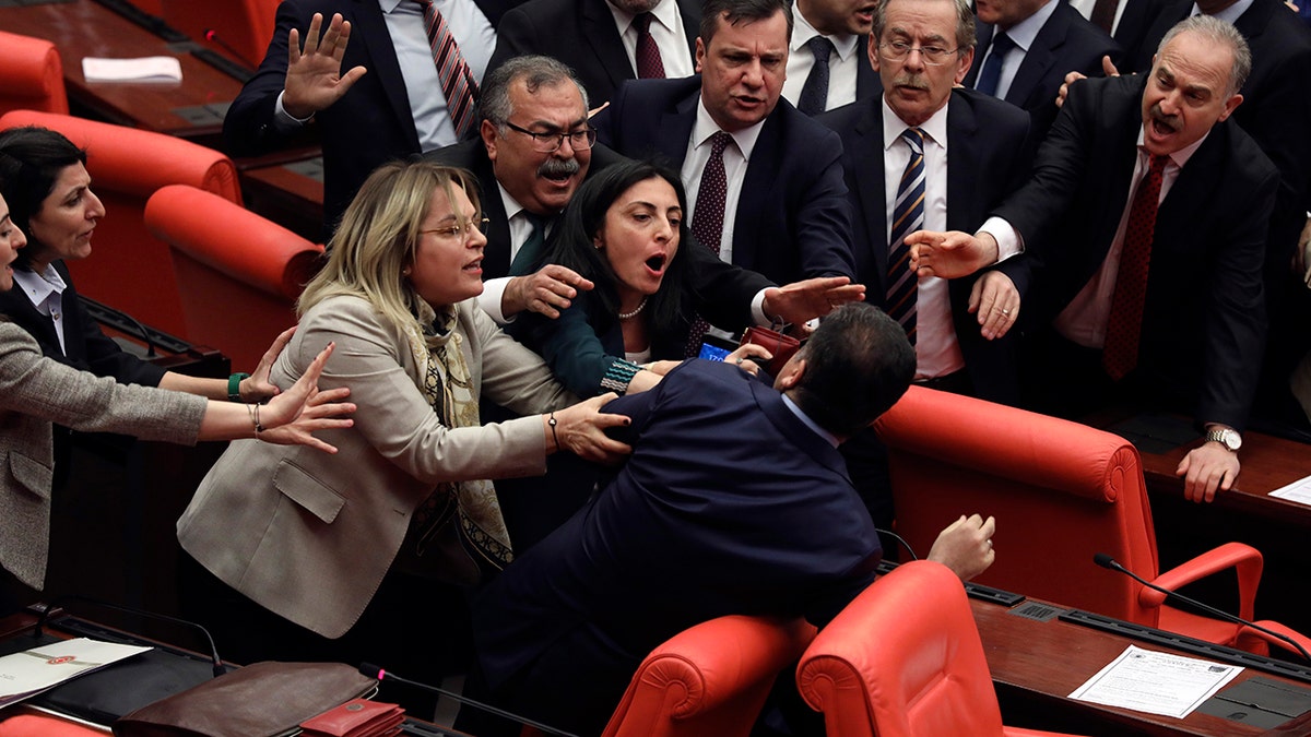 Legislators push each other as a brawl breaks out in Turkey's parliament in Ankara, Turkey, Wednesday, March 4, 2020. A fight broke out in the Turkish parliament between lawmakers from opposing parties during a tense discussion about Turkey's military involvement in northwest Syria. (AP Photo)
