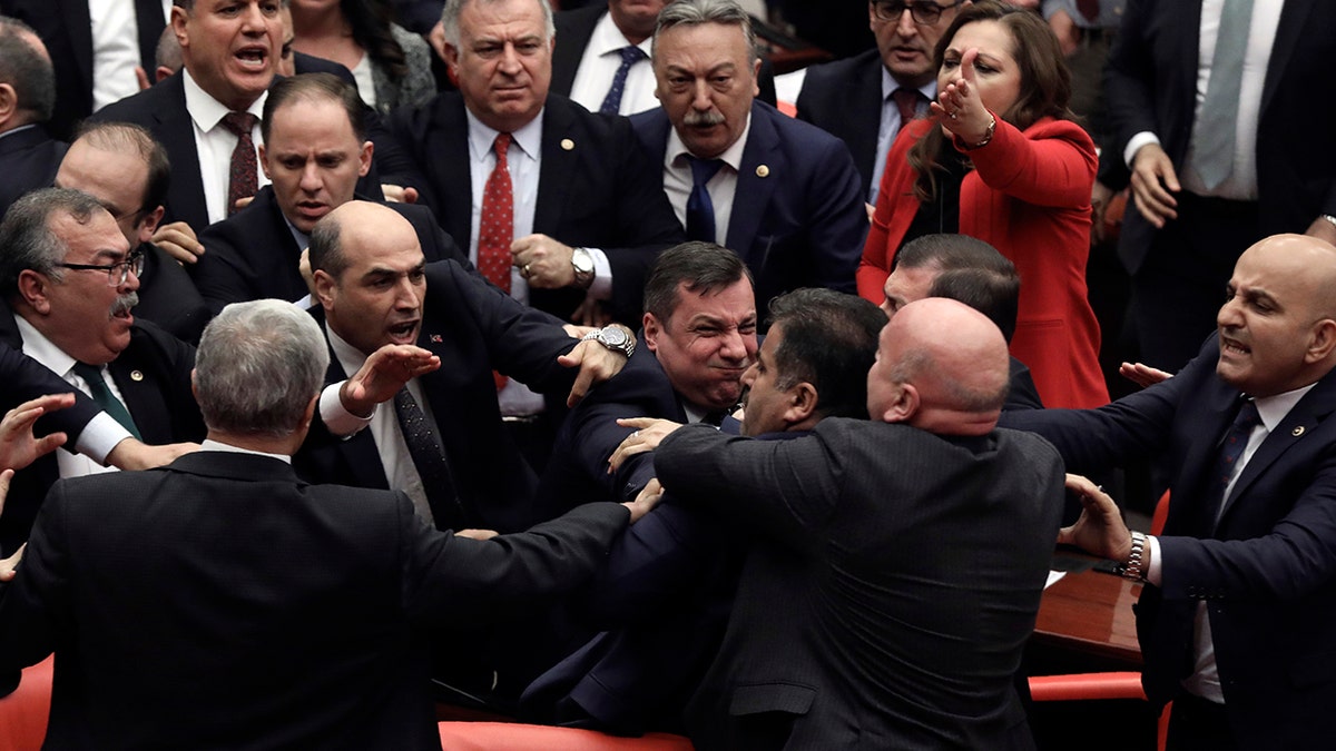 Legislators push each other as a brawl breaks out in Turkey's parliament in Ankara, Turkey, Wednesday, March 4, 2020. A fight broke out in the Turkish parliament between lawmakers from opposing parties during a tense discussion about Turkey's military involvement in northwest Syria. (AP Photo)