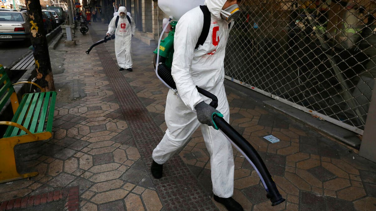 Firefighters disinfect a sidewalk to help prevent the spread of the new coronavirus in Tehran, Iran, Thursday, March 5, 2020. Iran has one of the highest death tolls in the world from the new coronavirus outside of China, the epicenter of the outbreak. (AP Photo/Vahid Salemi)