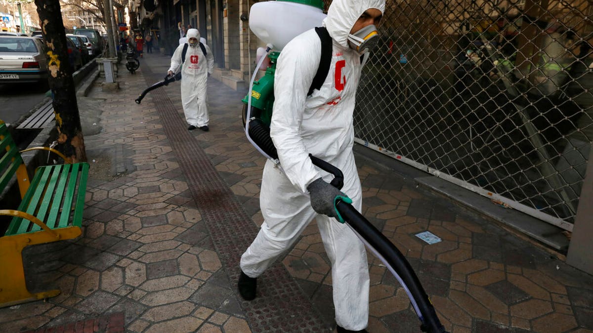 Firefighters disinfect a sidewalk to help prevent the spread of the new coronavirus in Tehran, Iran, Thursday, March 5, 2020. Iran has one of the highest death tolls in the world from the new coronavirus outside of China, the epicenter of the outbreak. (AP Photo/Vahid Salemi)