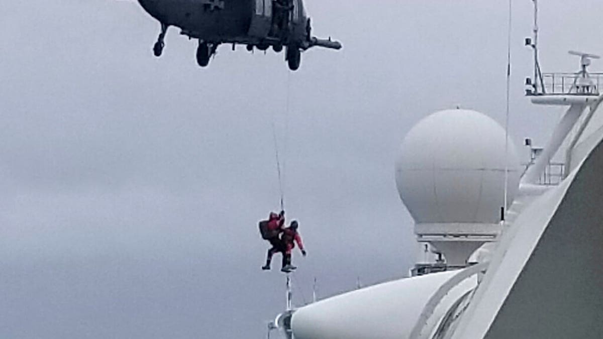 In this photo provided by Michele Smith, a National Guard helicopter delivering virus testing kits lowers crew down to the Grand Princess cruise ship Thursday, March 5, 2020, off the California coast.
