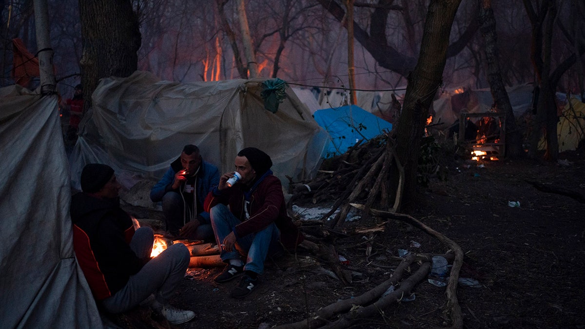Migrants gather at a makeshift camp near the Pazarkule border gate at the Turkish-Greek border in Edirne region, on Saturday, March 7, 2020. A group of migrants on Saturday tried to bring down a fence in a desperate attempt to bust through the border into Greece while others hurled rocks at Greek police. Greek authorities responded, firing volleys of tear gas at the youths. (AP Photo/Felipe Dana)