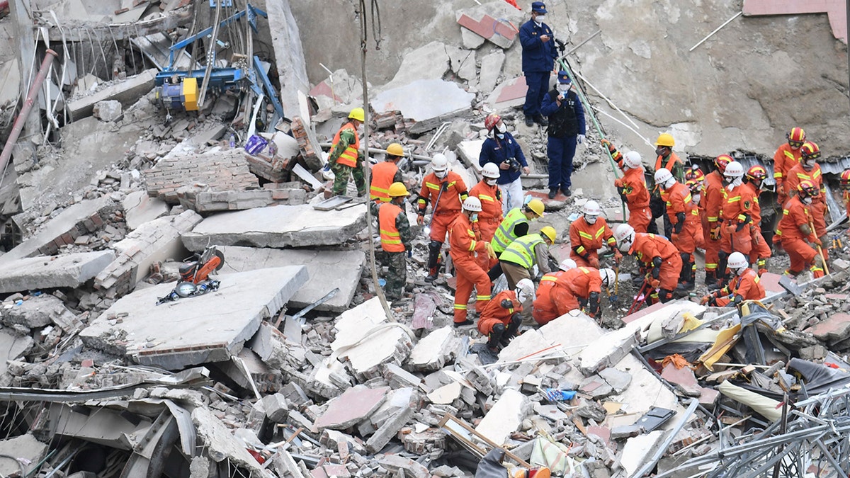 In this photo released by Xinhua News Agency, rescuers search for victims at the site of a hotel collapse in Quanzhou, southeast China's Fujian Province, Sunday, March 8, 2020. Several people were killed and others trapped in the collapse of the Chinese hotel that was being used to isolate people who had arrived from other parts of China hit hard by the coronavirus outbreak, authorities said Sunday. (Lin Shanchuan/Xinhua via AP)