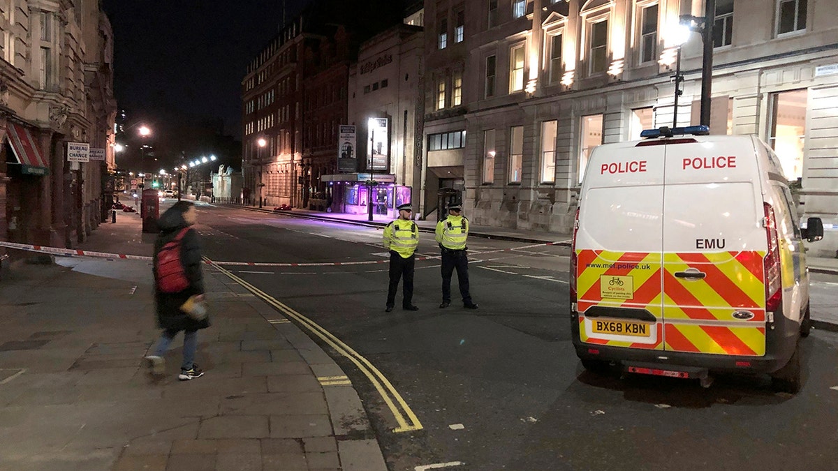 Police stand guard by a cordoned off area after an incident in Westminster, London, early Monday, March 9, 2020. British police say they have shot dead a man who was brandishing two knives near Trafalgar Square in central London. The Metropolitan Police force said Monday that the shooting was not related to terrorism. (Scott D'Arcy/PA via AP)