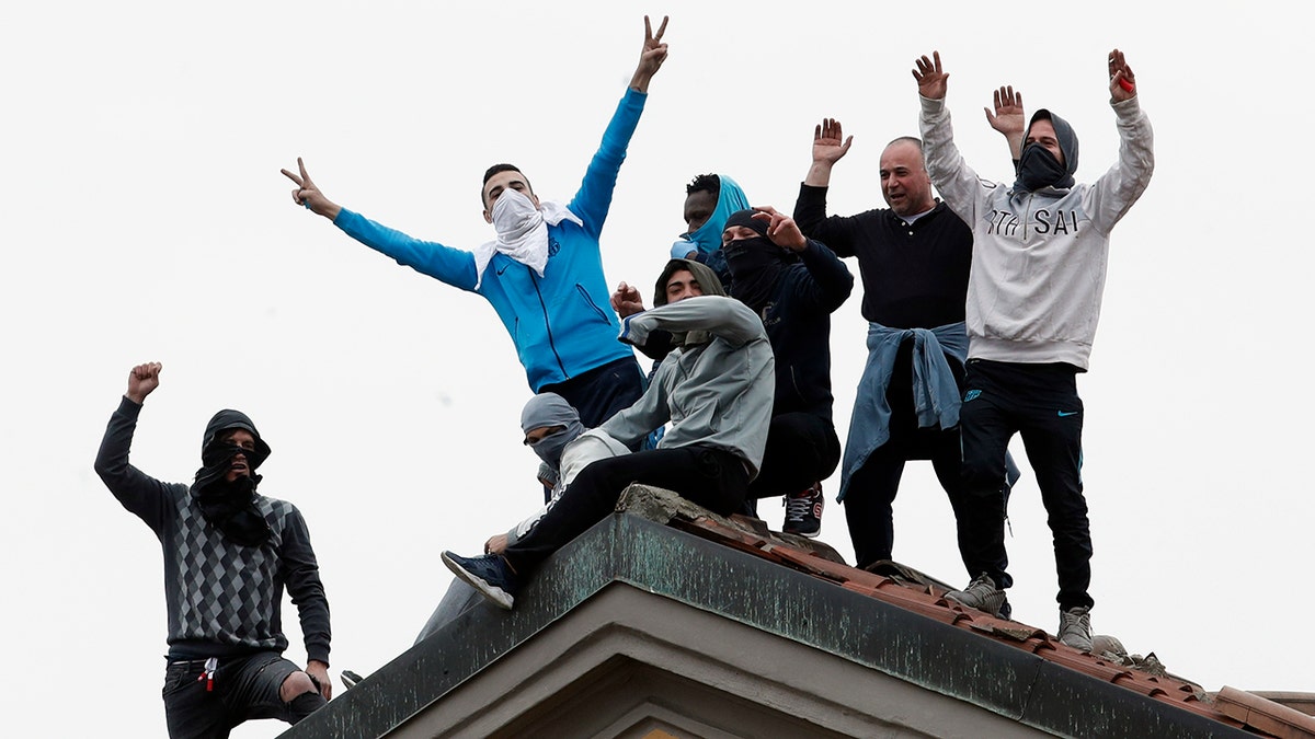 Inmates stage a protest against new rules to cope with coronavirus emergency, atop the roof of the San Vittore prison in Milan, Italy, Monday, March 9, 2020. Italy took a page from China's playbook Sunday, attempting to lock down 16 million people — more than a quarter of its population — for nearly a month to halt the relentless march of the new coronavirus across Europe. (AP Photo/Antonio Calanni)
