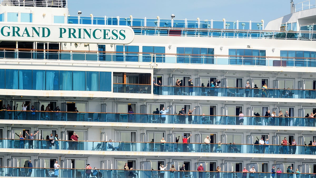 Passenger aboard the Grand Princess celebrate as they arrive in Oakland, Calif., on Monday, March 9, 2020. The cruise ship, which had maintained a holding pattern off the coast for days, is carrying multiple people who tested positive for COVID-19, a disease caused by the new coronavirus. (AP Photo/Noah Berger)