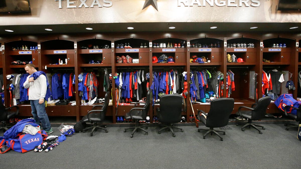 Texas Rangers pitcher Sam Dyson, left, packs a bag in the locker room at the baseball park in Arlington, Texas. 