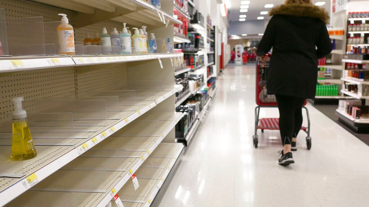 FILE: Shelves that held hand sanitizer and hand soap are mostly empty at a Target in Jersey City, N.J.