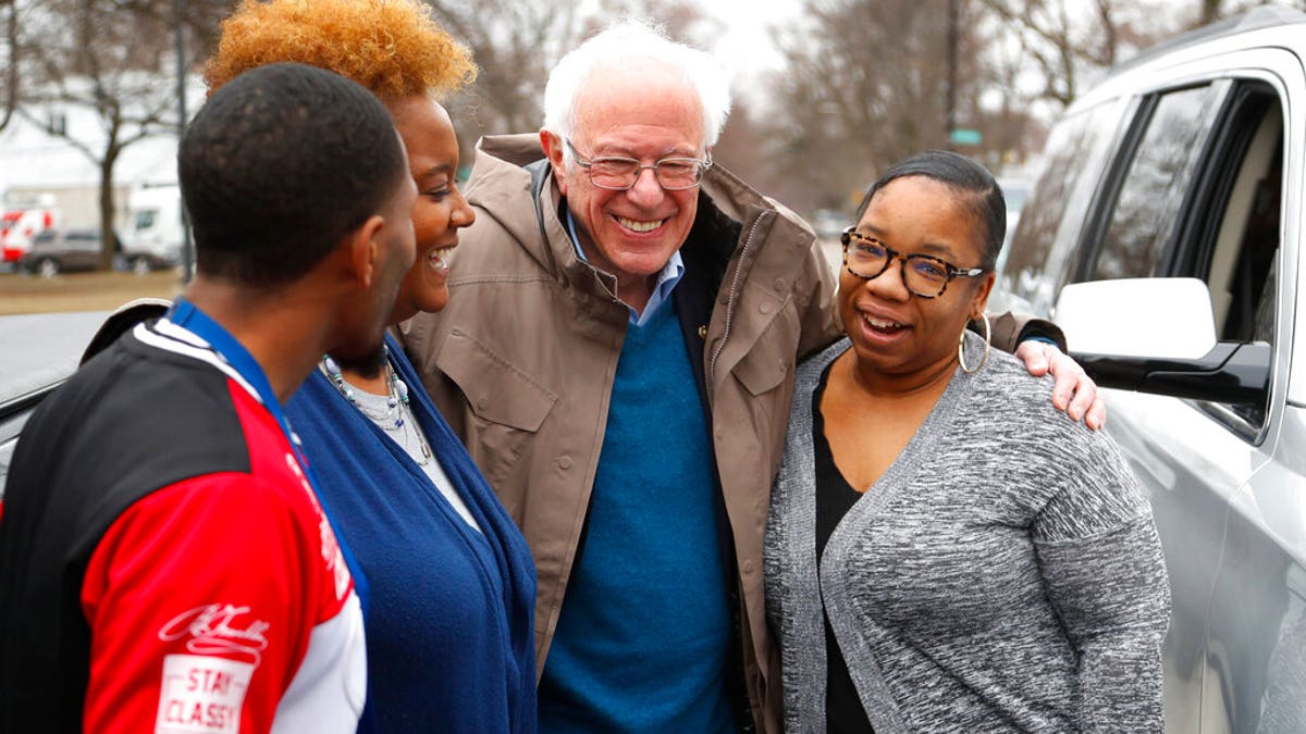 Democratic presidential candidate Sen. Bernie Sanders, I-Vt., visits custodian Davonta Bynes, from left, principal DaRhonda Evans-Stewart and social worker Kim Little outside a polling location at Warren E. Bow Elementary School in Detroit, Tuesday, March 10, 2020. (AP Photo/Paul Sancya)