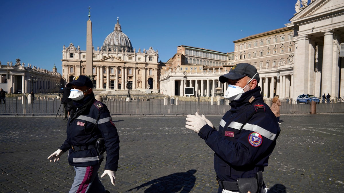 Police officers wearing masks patrol an empty St. Peter's Square at the Vatican, Wednesday, March 11, 2020. Pope Francis held his weekly general audience in the privacy of his library as the Vatican implemented Italy’s drastic coronavirus lockdown measures, barring the general public from St. Peter’s Square and taking precautions to limit the spread of infections in the tiny city state. (AP Photo/Andrew Medichini)