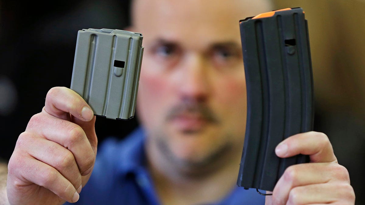 ​​​​​​​Jonathan Scalise, owner of Ammunition Storage Components, holds up a 10-round, left, and a 30-round magazine that his company manufacturers for the AR-15 rifle in New Britain, Conn., April 10, 2013. Gun rights supporters are suing Connecticut officials over part of a 2013 state gun control law passed after the Sandy Hook school shooting, saying it unconstitutionally bans people from loading more than 10 rounds of ammunition into their firearms. (Associated Press)