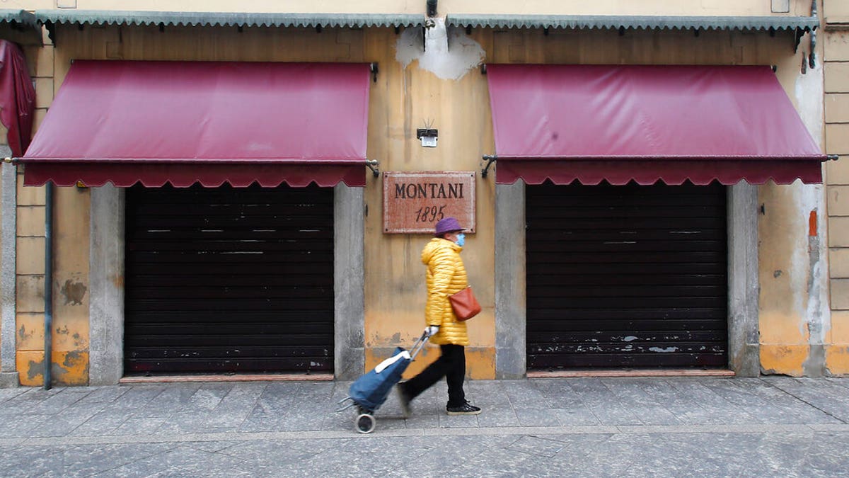 A woman walks in Codogno, Italy, Thursday, March 12, 2020. The northern Italian town that recorded Italy’s first coronavirus infection has offered a virtuous example to fellow Italians, now facing an unprecedented nationwide lockdown, that by staying home, trends can reverse. Infections of the new virus have not stopped in Codogno, which still has registered the most of any of the 10 Lombardy towns Italy’s original red zone, but they have slowed.