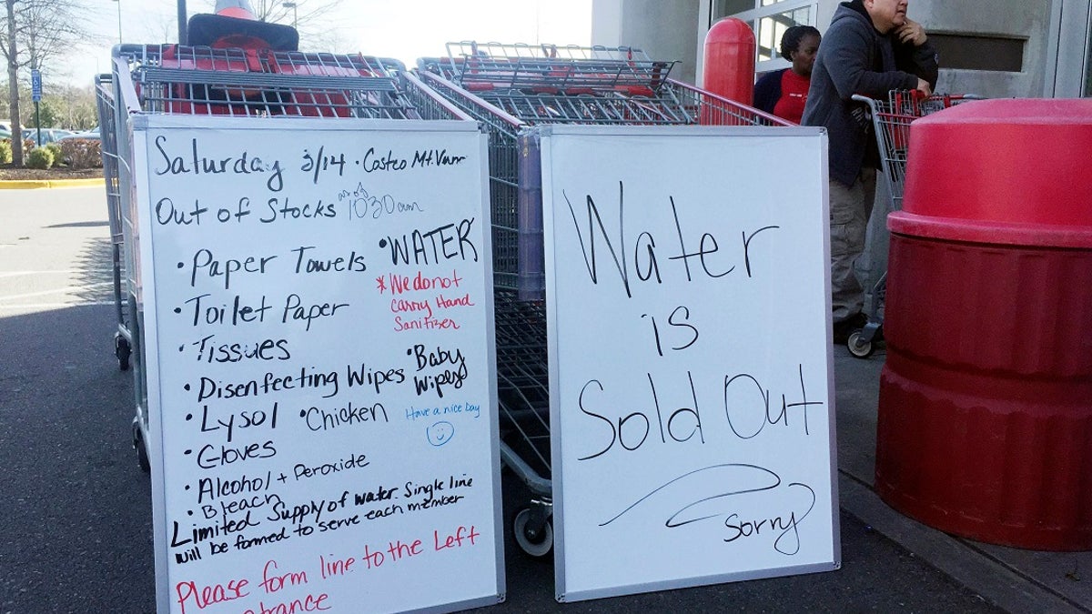 A sign outside a Costco warehouse store in Alexandria, Va., advises shoppers which items have sold out over the weekend. As fears of coronavirus grip the nation, Americans are rushing to stock up on staples and disinfectants. (AP Photo/Kevin S. Vineys)