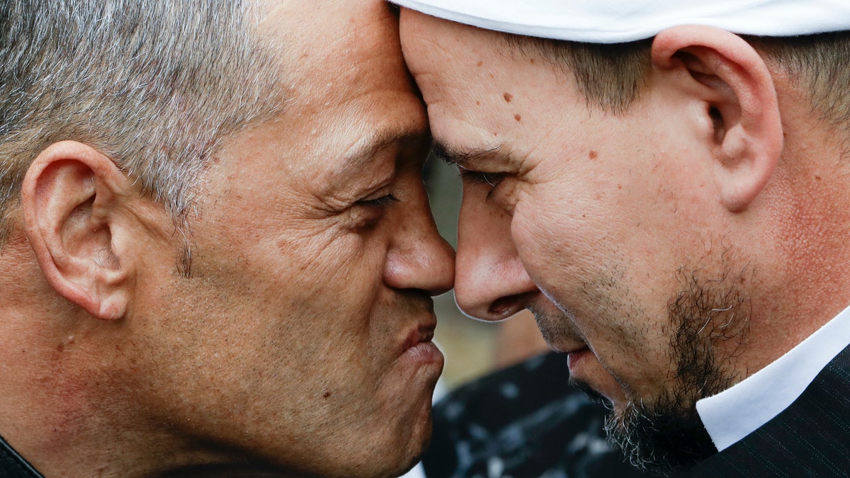 Imam of the Al Noor mosque Gamal Fouda, right, and Tu Tangata motorcycle club president Derek Tait exchange a hongi outside the mosque in Christchurch, New Zealand, Sunday, March 15, 2020. A national memorial in New Zealand to commemorate the 51 people who were killed when a gunman attacked two mosques one year ago has been canceled due to fears over the new coronavirus. (AP Photo/Mark Baker)