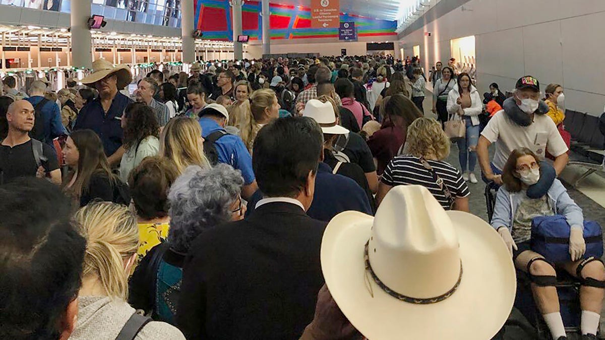In this photo provided by Austin Boschen, people wait in line to go through the customs at Dallas Fort Worth International Airport in Grapevine, Texas, Saturday, March 14, 2020. International travelers reported long lines at the customs at the airport Saturday as staff took extra precautions to guard against the new coronavirus, The Dallas Morning News reports. Boschen said it took him at least 4 hours to go through the customs. (Austin Boschen via AP)