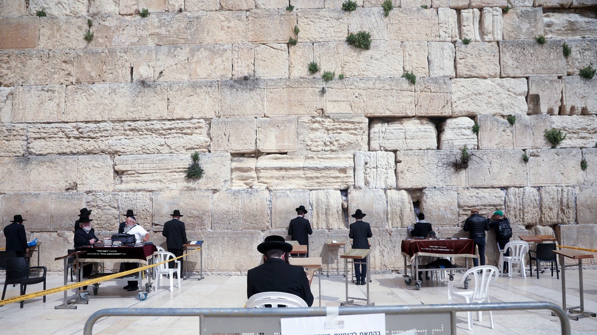 Ultra Orthodox Jews pray at the Western Wall in Jerusalem, Sunday, March 15, 2020. Israel imposed sweeping travel and quarantine measures more than a week ago but has seen its number of confirmed coronavirus cases double in recent days, to around 200. On Saturday, the government said restaurants, malls, cinemas, gyms and daycare centers would close. (AP Photo/Mahmoud Illean)