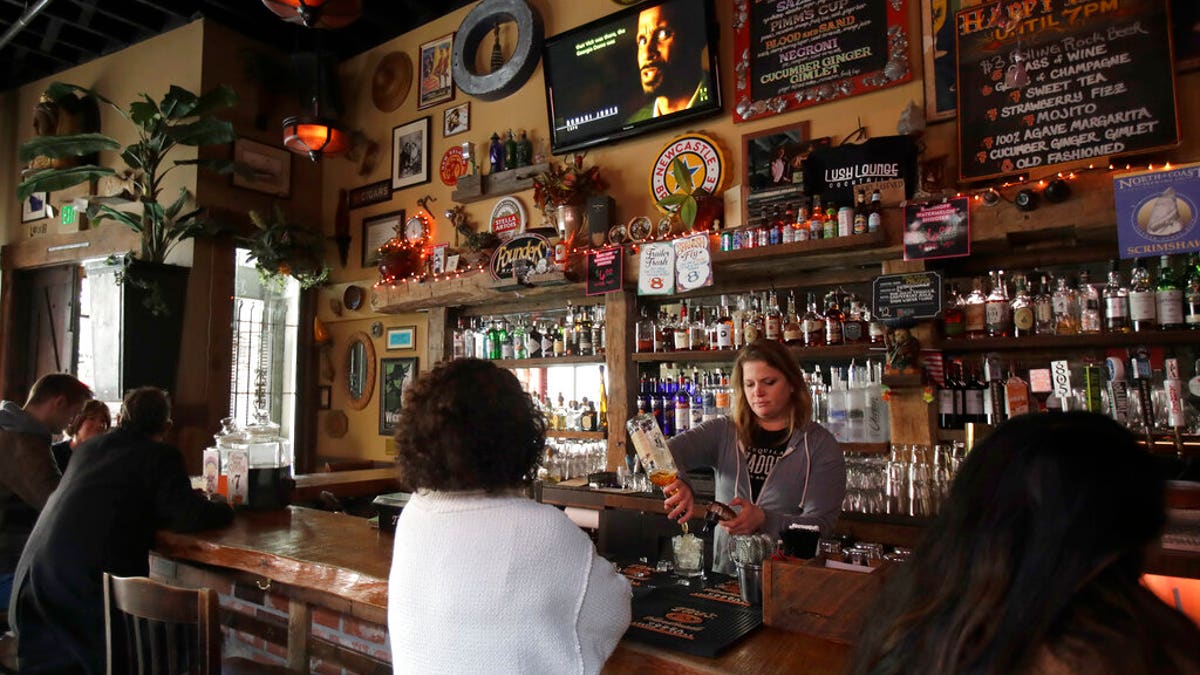 Bartender Lyndsay Przybyl, center rear, pours drinks for customers at Lush Lounge in San Francisco, Sunday, March 15, 2020.
