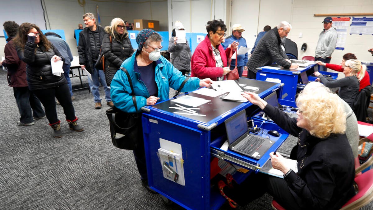 Chicago residents line up for early voting at the Roden Library Monday, March 16, 2020, in Chicago. (AP Photo/Charles Rex Arbogast)