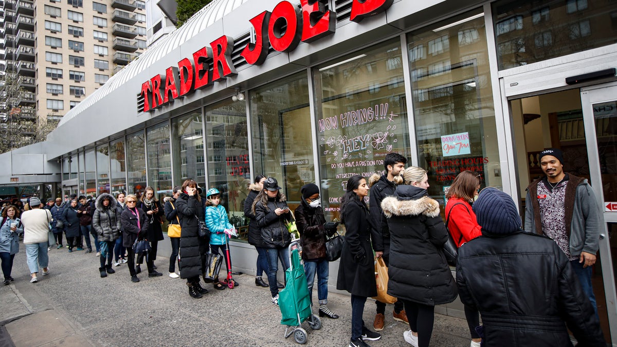 Customers wait on line outside a supermarket, Monday, March 16, 2020, in New York. (AP Photo/John Minchillo)