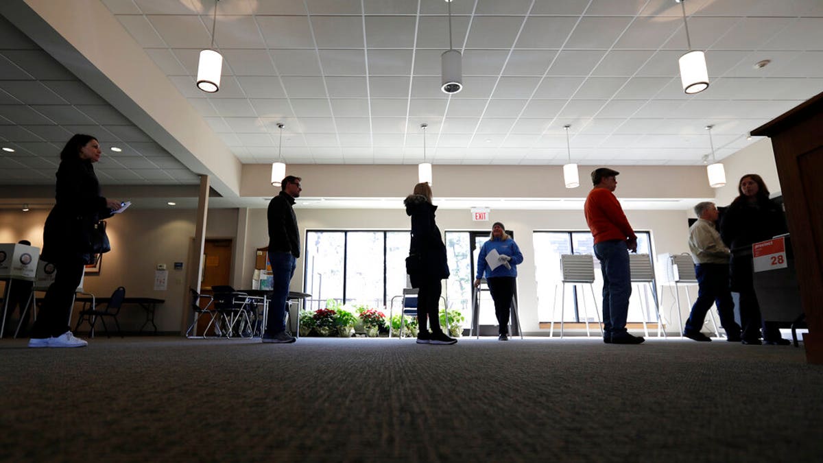 Evanston residents line up for voting at Trinity Lutheran Church in Evanston, Ill., Tuesday, March 17, 2020. Some polling places in Evanston have been moved in an effort to reduce exposure of senior citizens to the COVID-19 coronavirus.(AP Photo/Nam Y. Huh)