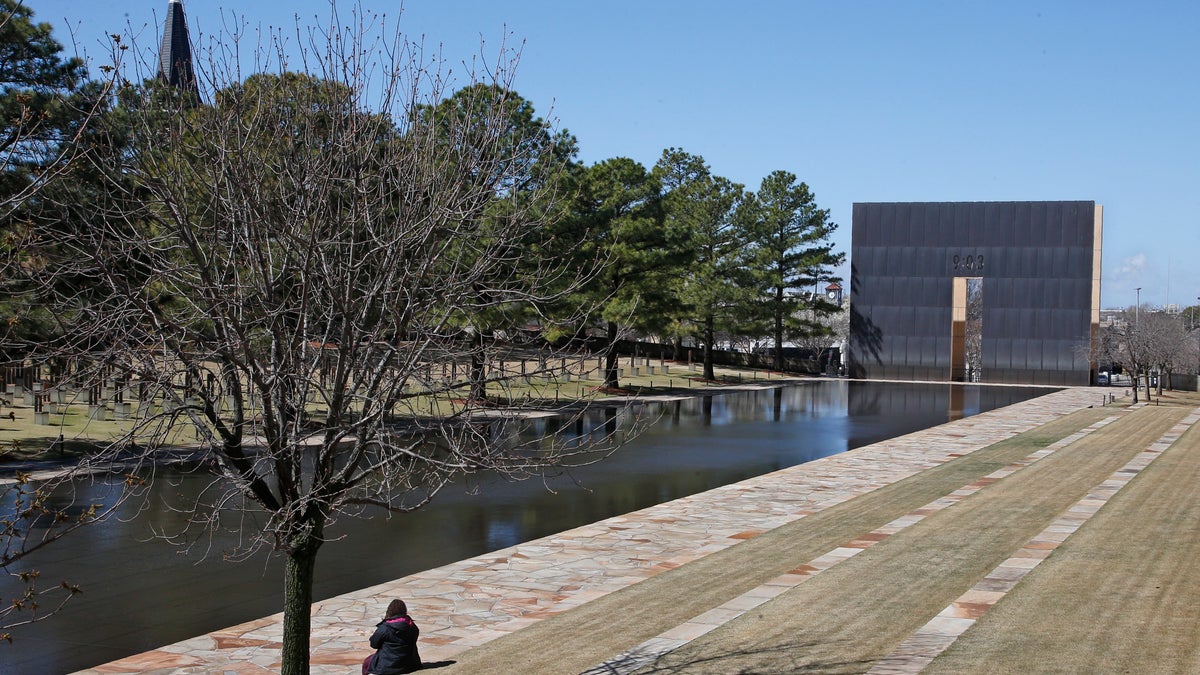 A visitor sits next to the reflecting pool at the Oklahoma City National Memorial and Museum in Oklahoma City, Okla., March 18, 2020. (Associated Press)