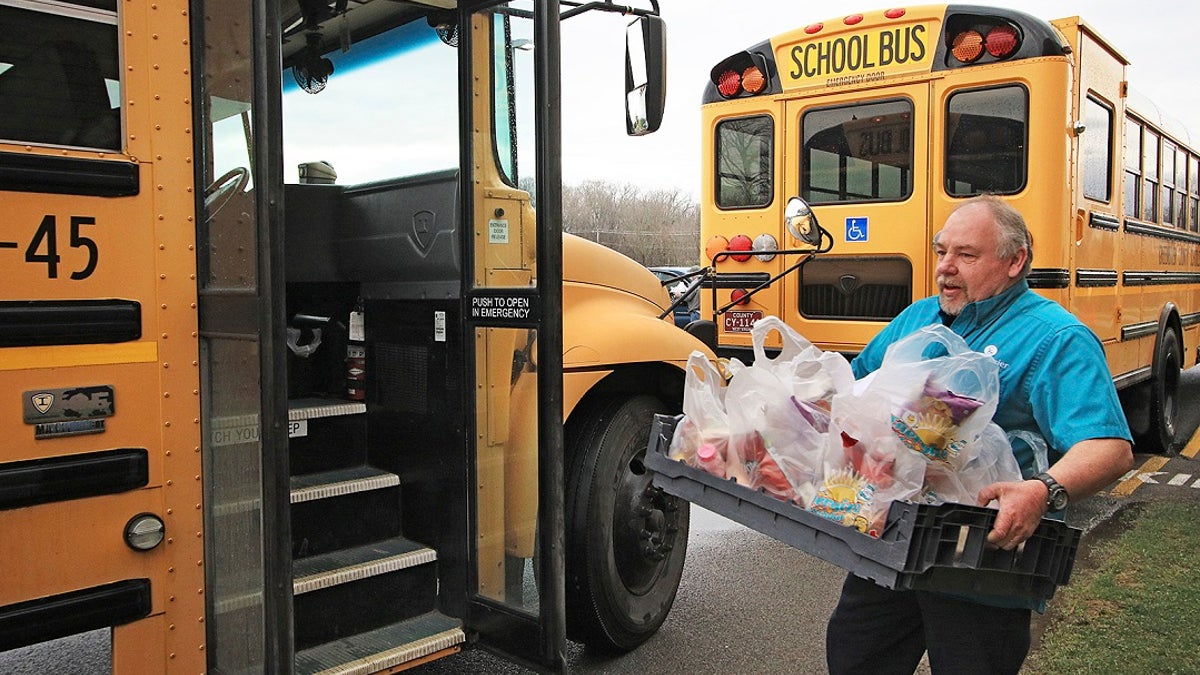Bus driver Tim Smith loads his bus up with breakfast and lunches for delivery at Ronceverte Elementary on Thursday in Ronceverte, W.Va. Bus drivers will be delivering meals through the rest of the week and volunteers with the Greater Greenbrier Long-term Recovery Committee will be taking over delivery starting Monday. (Jenny Harnish/The Register-Herald via AP)