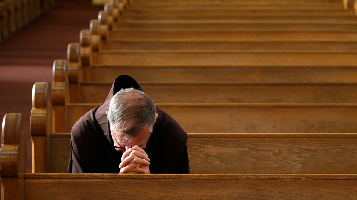 Rev. Micah Muhlen, OFM, prays prior to a modest and shortened service at St. Mary's Roman Catholic Basilica, attended by very few parishioners due to the coronavirus, Sunday, March 22, 2020, in Phoenix. (AP Photo/Ross D. Franklin)