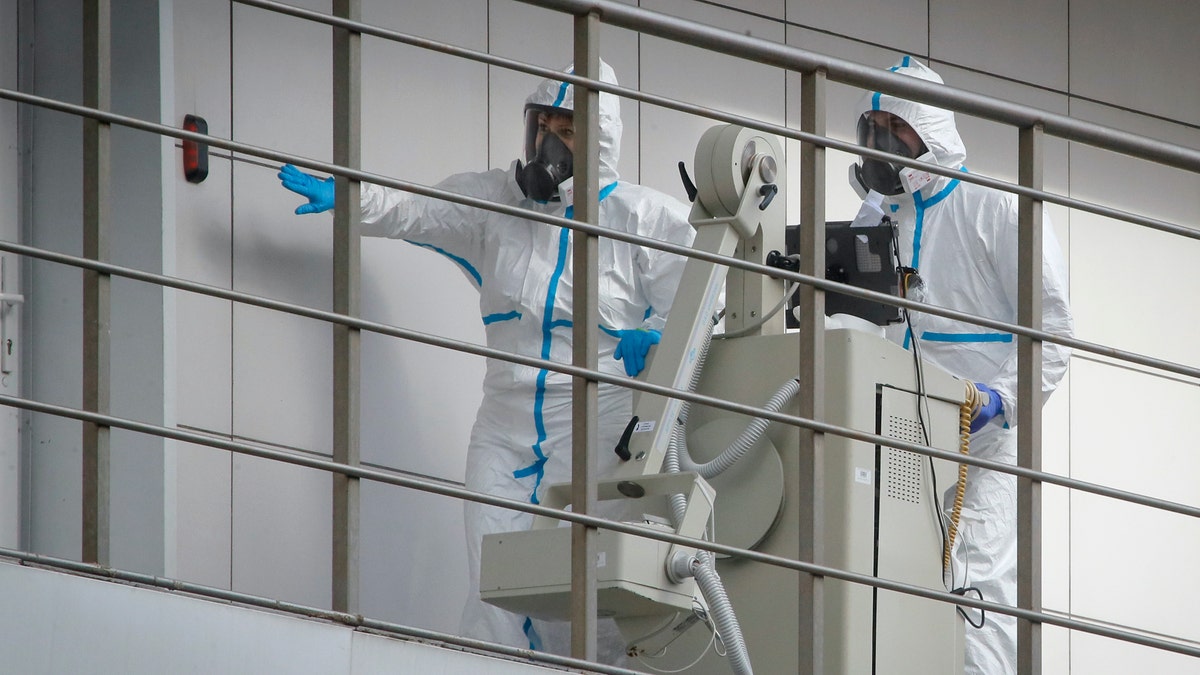 Medical workers move a medical device at the Botkin isolation hospital, where patients are kept in isolation for possible inflection by the new coronavirus, in St.Petersburg, Russia, Tuesday, March 24, 2020, with Russia only reporting a few hundred virus cases. The highly contagious COVID-19 coronavirus can cause mild symptoms, but for some it can cause severe illness including pneumonia.