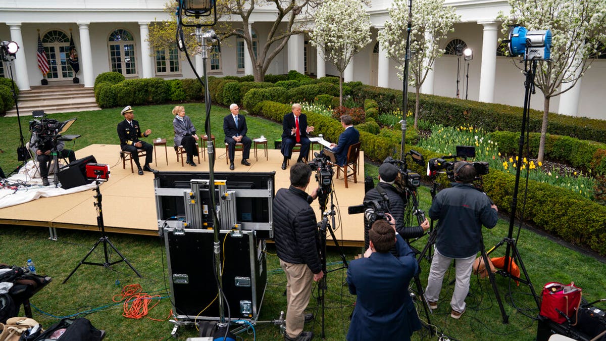 President Donald Trump speaks during a Fox News virtual town hall as from left, U.S. Surgeon General Jerome Adams, White House coronavirus response coordinator Dr. Deborah Birx and Vice President Mike Pence listen, in the Rose Garden at the White House, Tuesday, March 24, 2020, in Washington. (AP Photo/Evan Vucci)