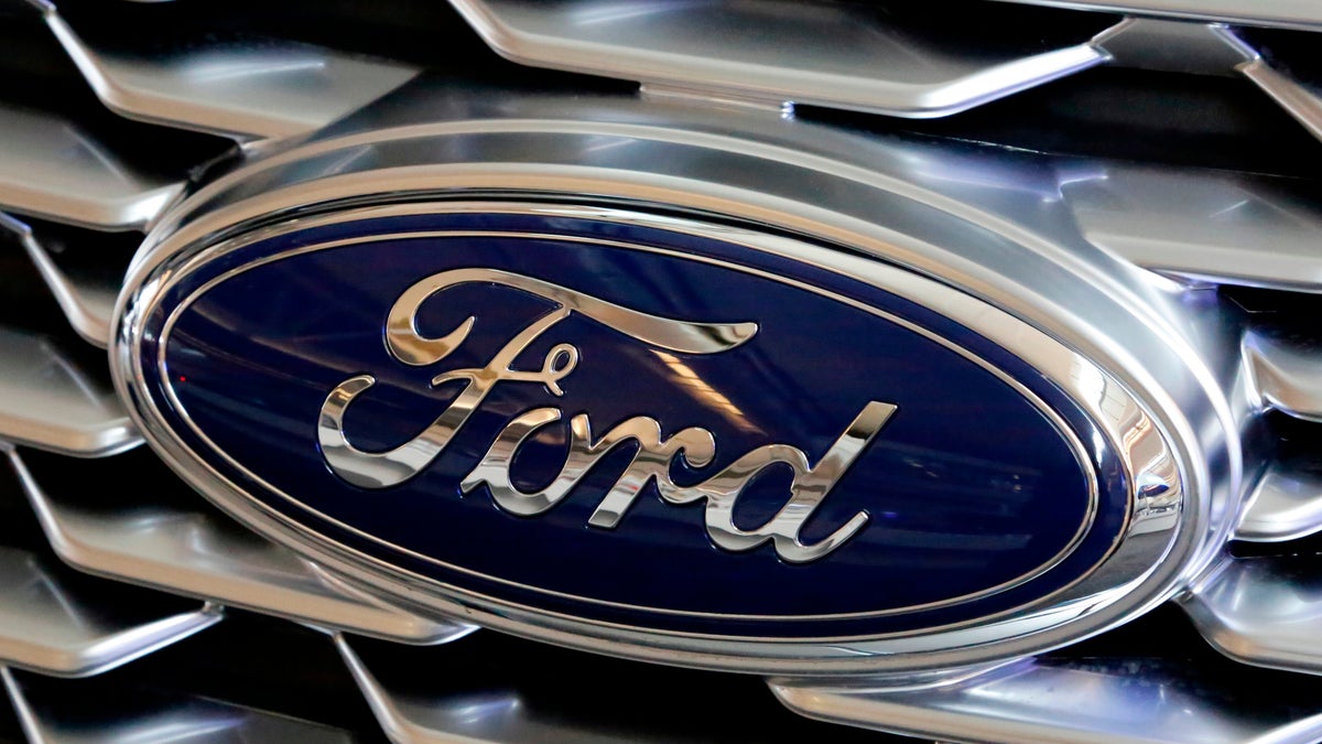 A Ford logo on the grill of a 2018 Ford Explorer on display at the Pittsburgh Auto Show in Feb. 2018. Ford Motor Company has announced plans to make 50,000 ventilators at one of its Michigan plants over the next 100 days in an effort to arm those on the front lines with equipment to fight COVID-19. (AP Photo/Gene J. Puskar, File)