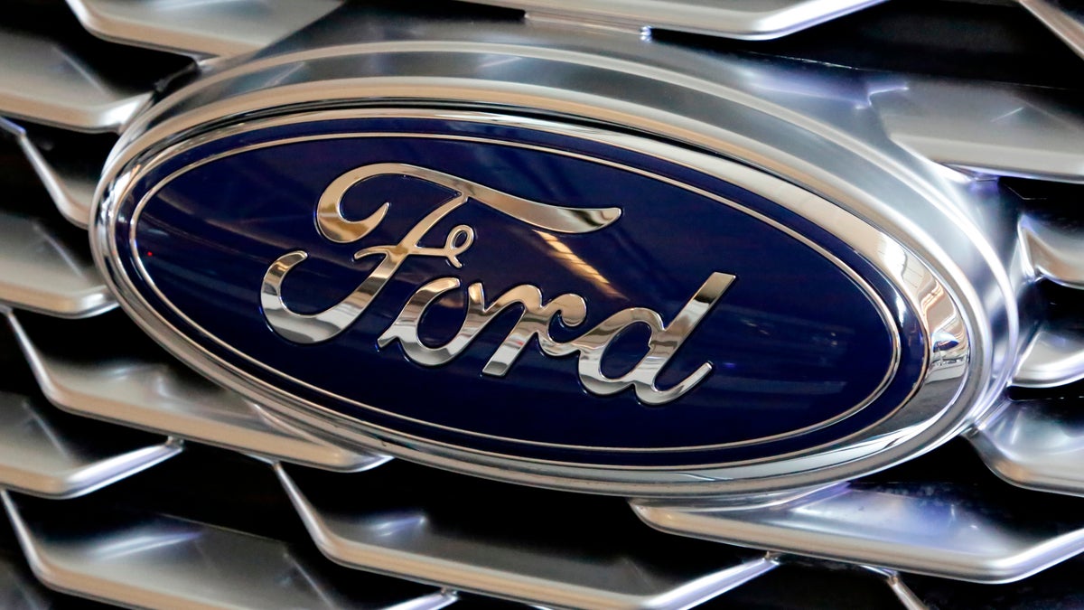 A Ford logo on the grill of a 2018 Ford Explorer on display at the Pittsburgh Auto Show in Feb. 2018. Ford Motor Company has announced plans to make 50,000 ventilators at one of its Michigan plants over the next 100 days in an effort to arm those on the front lines with equipment to fight COVID-19. (AP Photo/Gene J. Puskar, File)