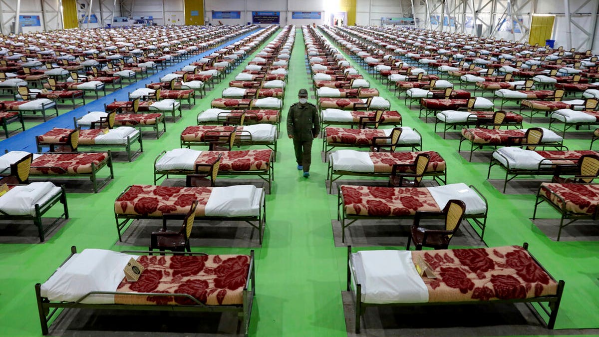 An Iranian army soldier walks past rows of beds at a temporary 2,000-bed hospital for COVID-19 coronavirus patients set up by the army at the international exhibition center in northern Tehran, Iran, on Thursday, March 26, 2020.