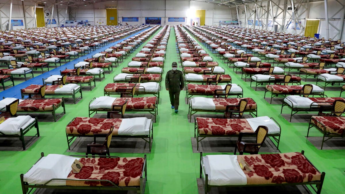 An Iranian army soldier walks past rows of beds at a temporary 2,000-bed hospital for COVID-19 coronavirus patients set up by the army at the international exhibition center in northern Tehran, Iran, on Thursday, March 26, 2020.