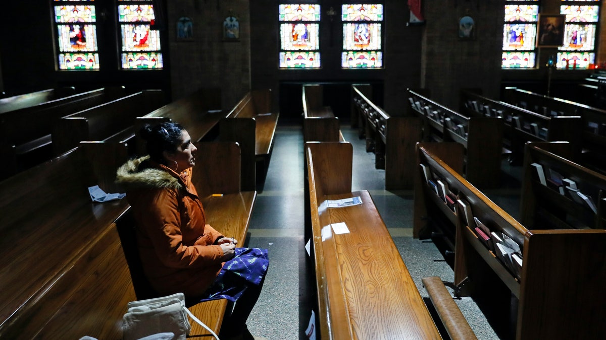 Parishioner Maria Torres, of Des Moines, Iowa, prays the Rosary in an empty St. Anthony's Catholic Church, Friday, March 27, 2020, in Des Moines, Iowa. Daily masses continue to be available online in response to the new coronavirus outbreak but the church is open daily for private prayers. 