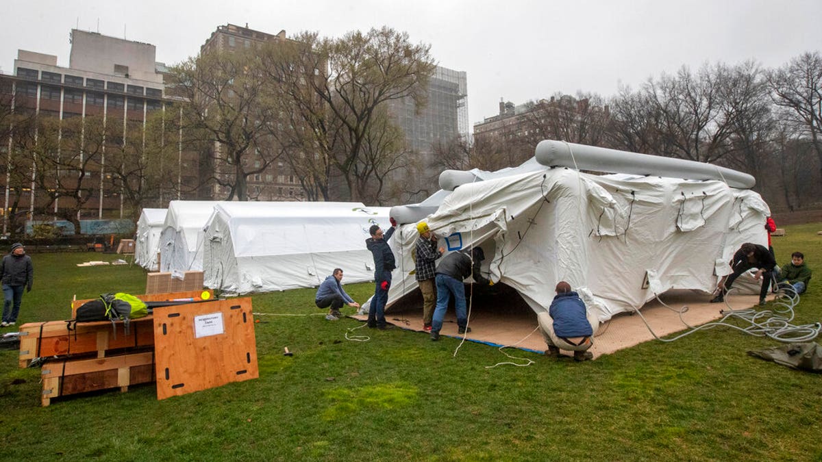 A Samaritan's Purse crew works on building an emergency field hospital equipped with a respiratory unit in New York's Central Park across from the Mount Sinai Hospital, Sunday, March 29, 2020. (AP Photo/Mary Altaffer)