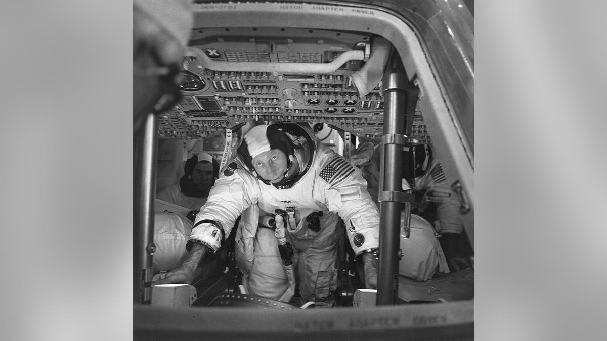 This March 26, 1971 photo made available by NASA shows astronauts Al Worden, center, Dave Scott, left, and Jim Irwin in the Command Module for an altitude chamber test at Cape Canaveral, Fla.