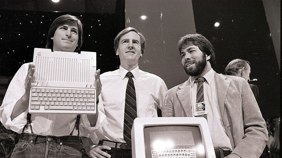 Steve Jobs, left, chairman of Apple Computers, John Sculley, center, president and CEO, and Steve Wozniak, co-founder of Apple, unveil the new Apple IIc computer in San Francisco, April 24, 1984. (AP Photo/Sal Veder)